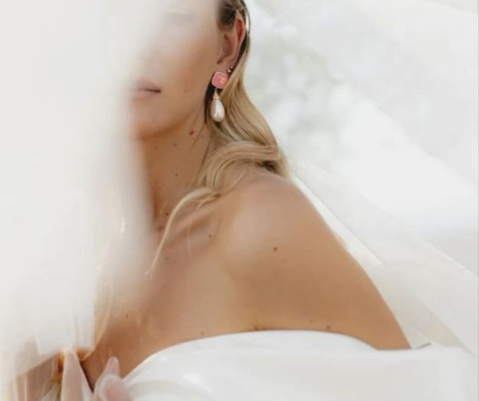 Soft bridal portrait with veil and pearl earring, used to illustrate long-lasting wedding hair styling.