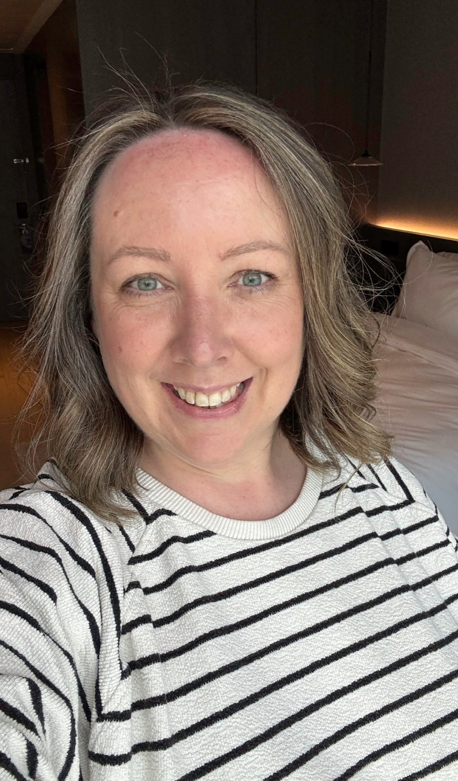 Karen Constantine smiling with shorter, highlighted hair after her haircut and colour